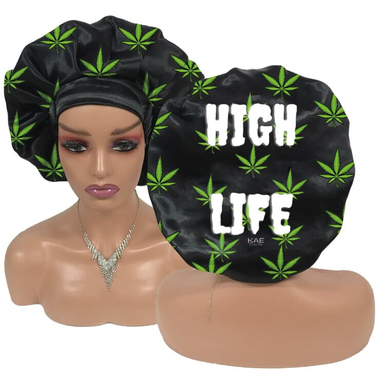 Black satin bonnet with marijuana leaf pattern and 'HIGH LIFE' text on a mannequin head and stand.